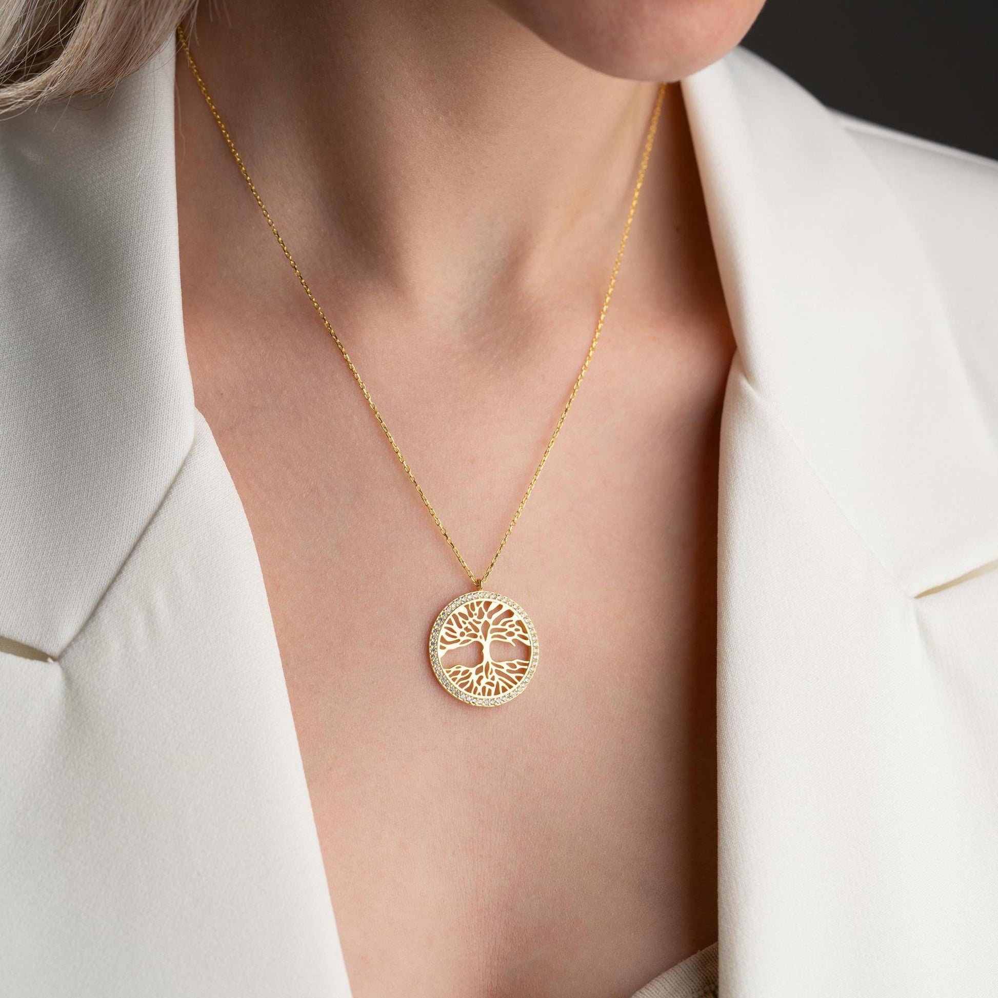 Tree of Life necklace with cubic zirconia stones, available in 925 sterling silver and 14K gold plated options, displayed on a white satin background.