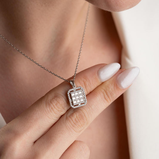 Square baguette pendant necklace with cubic zirconia stones, available in 925 sterling silver and 14K gold plated options, displayed on a white satin background