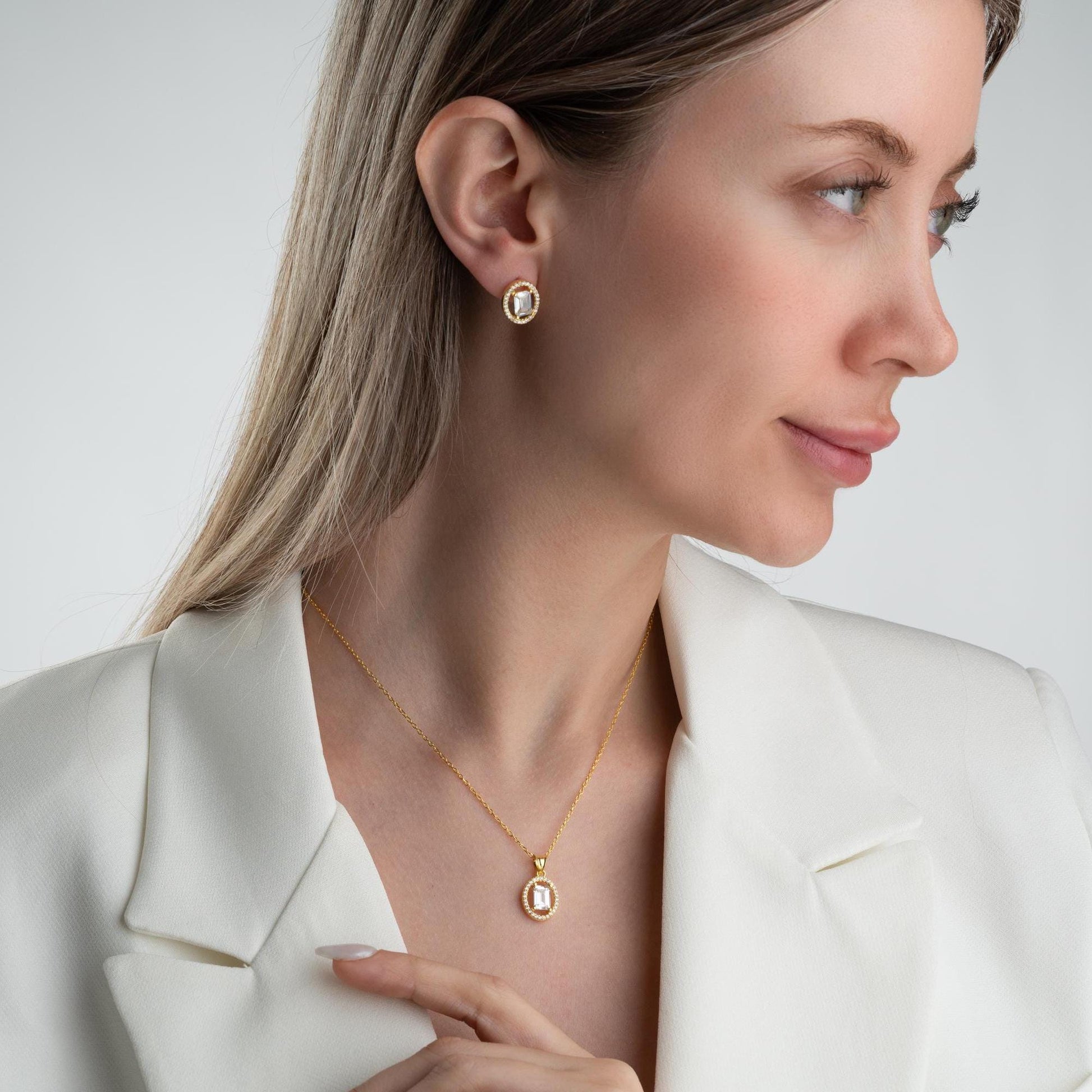 Oval elegance jewelry set with pendant necklace and earrings, featuring cubic zirconia stones, available in 925 sterling silver and 14K gold-plated options.