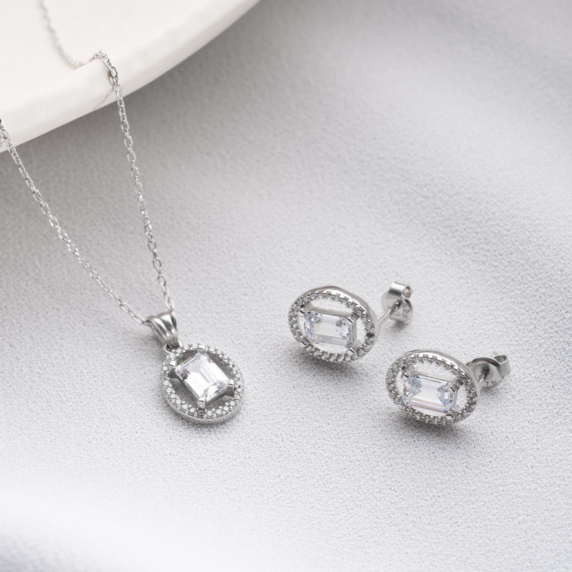 Oval elegance jewelry set with pendant necklace and earrings, featuring cubic zirconia stones, available in 925 sterling silver and 14K gold-plated options.