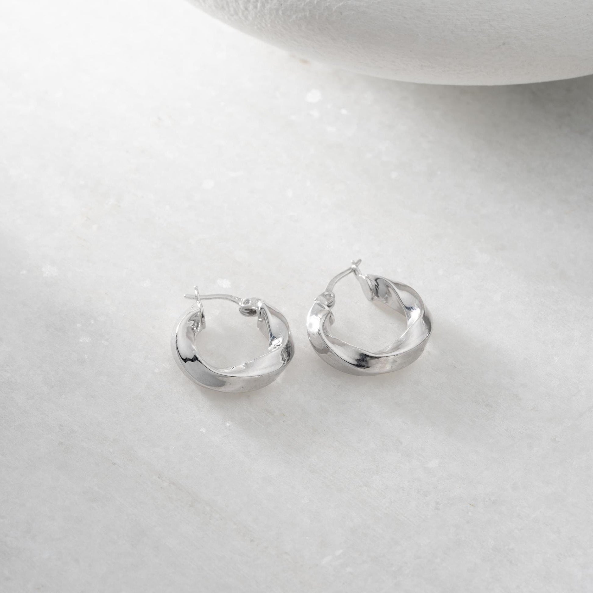 Twist hoop earrings in 925 Sterling Silver and 14K Gold Plated options, perfect for minimalist and elegant looks.
