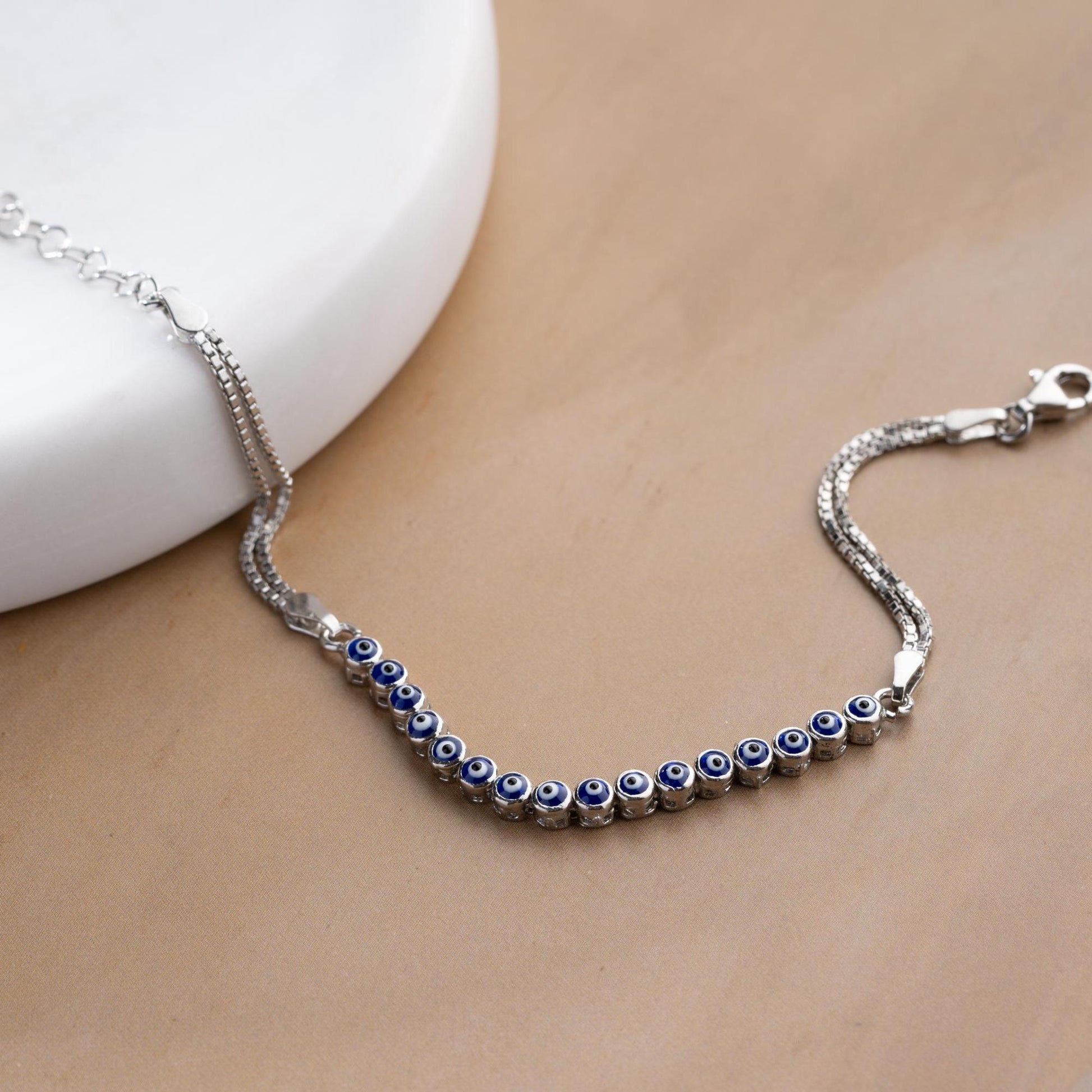 Evil eye bracelet crafted from 925 sterling silver with a 14K gold-plated option, featuring protective and stylish evil eye charms.