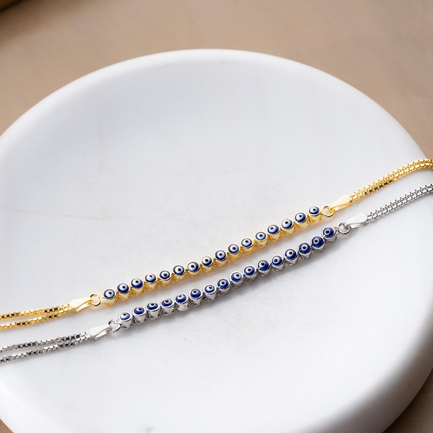 Evil eye bracelet crafted from 925 sterling silver with a 14K gold-plated option, featuring protective and stylish evil eye charms.