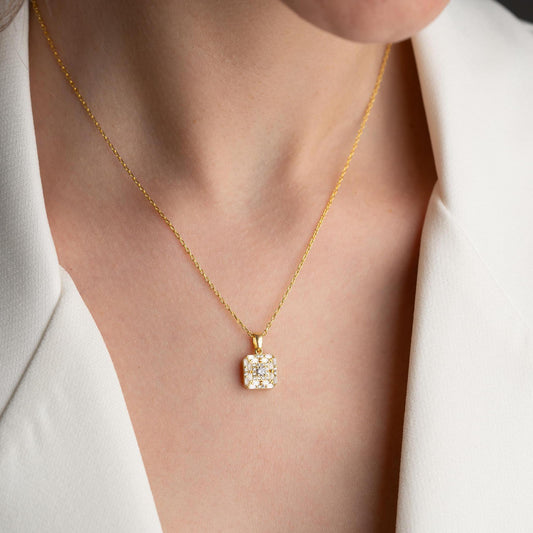 Square pendant necklace with cubic zirconia stones, available in 925 sterling silver and 14K gold plated options, displayed on a white satin background.
