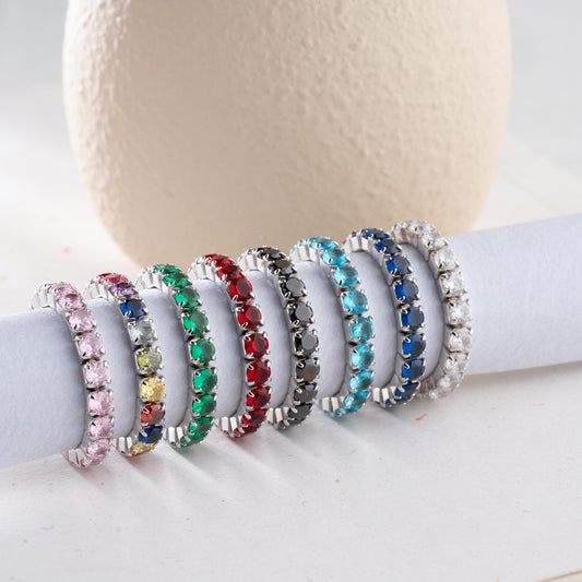 Single vibrant tennis ring crafted in 925 Sterling Silver with colorful cubic zirconia stones, available in rainbow, red, blue, green, black, and pink.