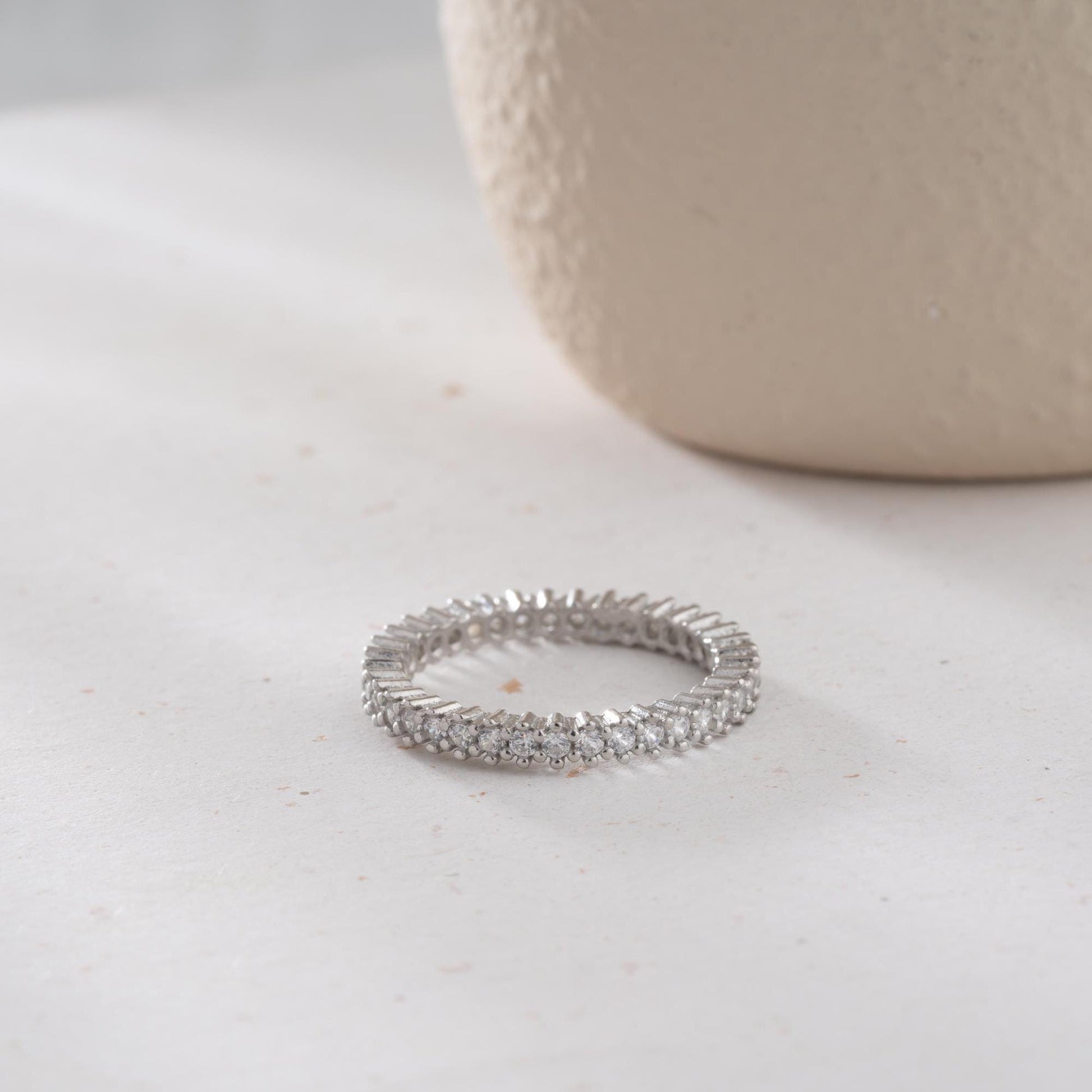 Elegant white zircon tennis ring made from 925 Sterling Silver, with brilliant stones set around the entire band. Adjustable and hypoallergenic.