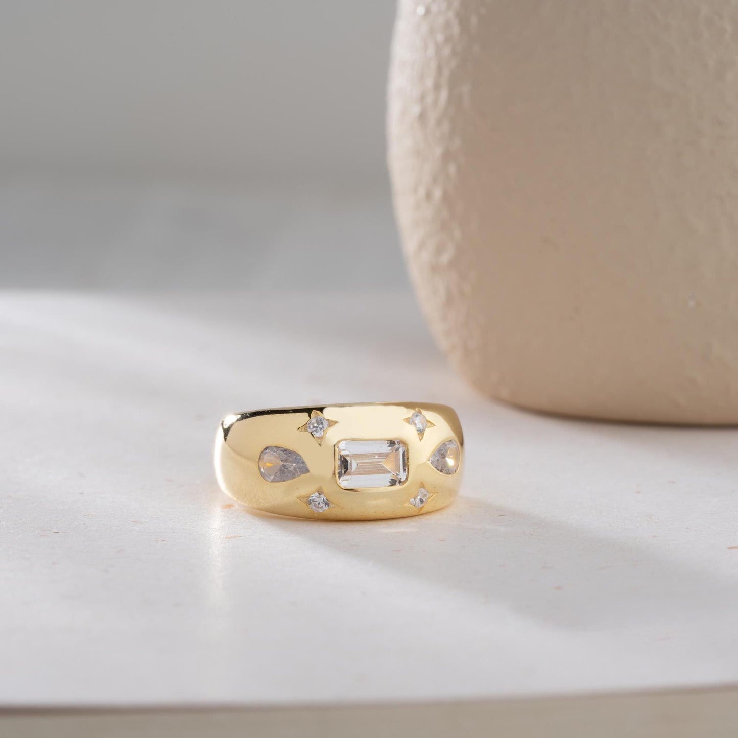 Baguette and teardrop cubic zirconia band ring in 925 sterling silver and 14K gold plating, featuring celestial star motifs. Elegant statement ring for women.