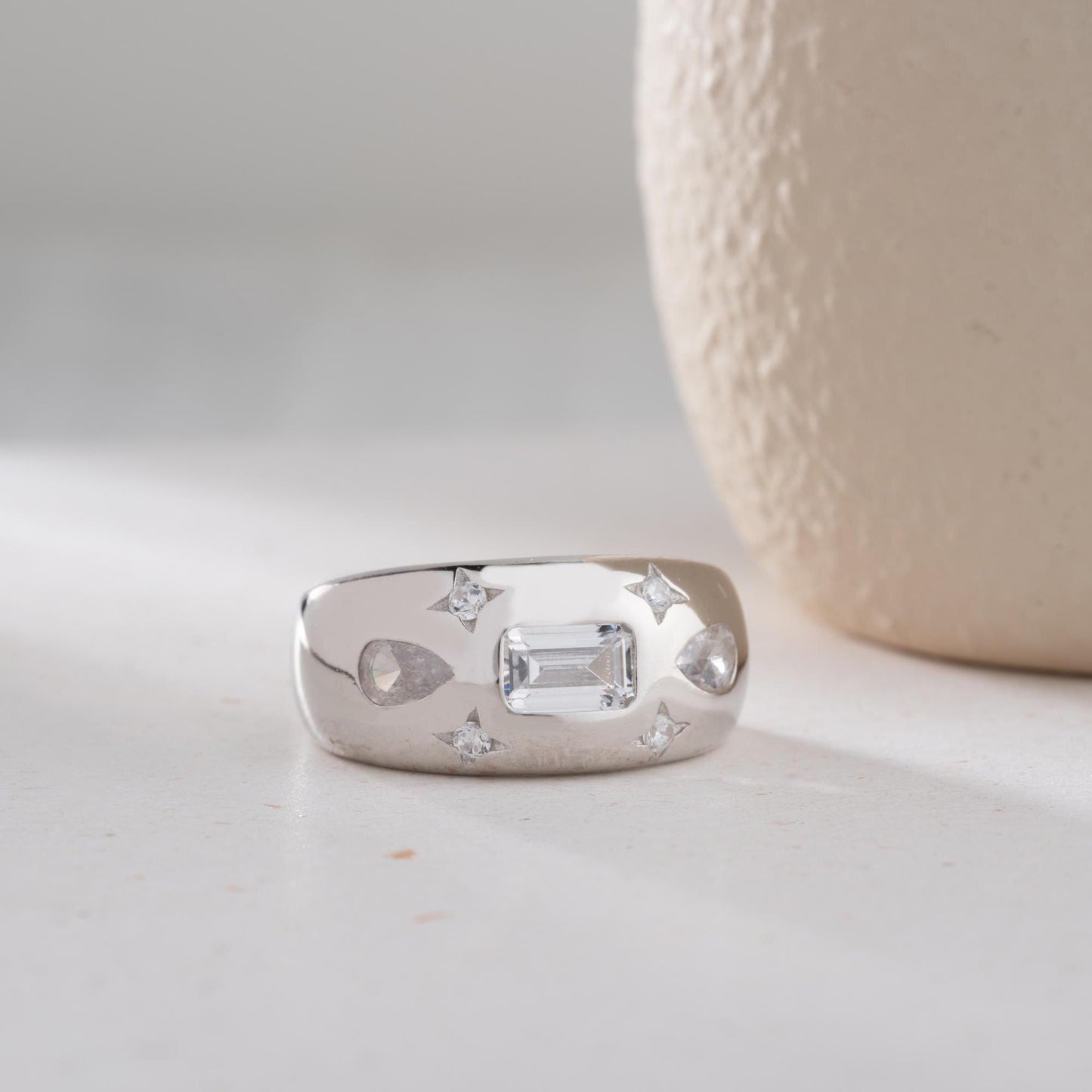 Baguette and teardrop cubic zirconia band ring in 925 sterling silver and 14K gold plating, featuring celestial star motifs. Elegant statement ring for women.