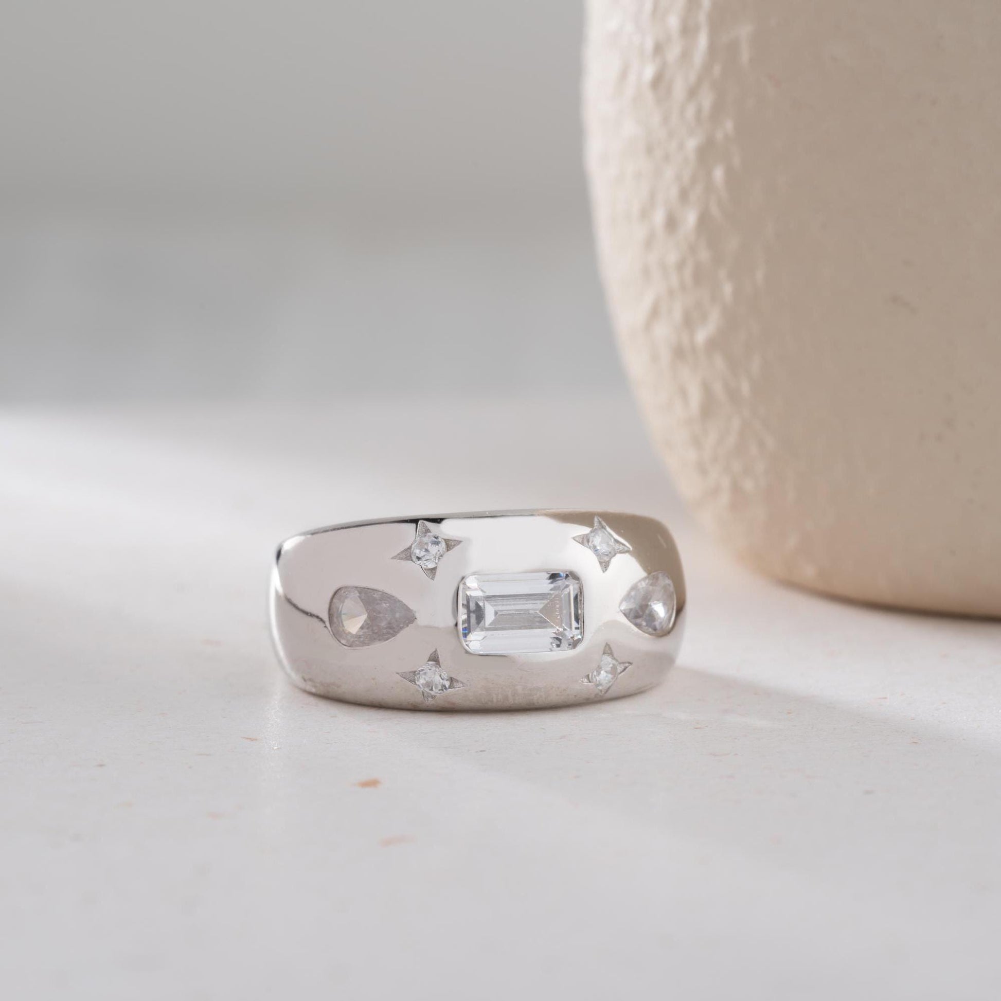 Baguette and teardrop cubic zirconia band ring in 925 sterling silver and 14K gold plating, featuring celestial star motifs. Elegant statement ring for women.