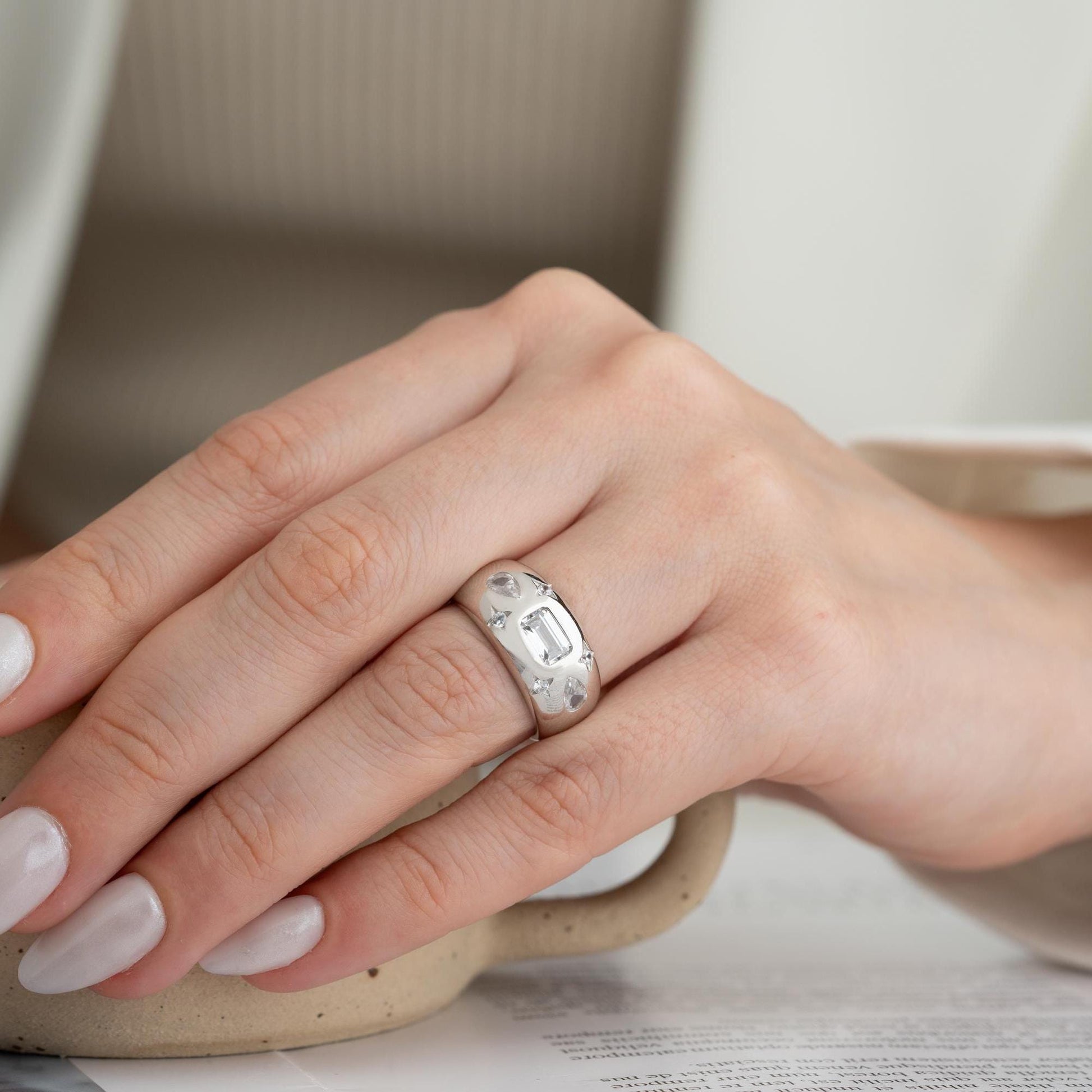 Baguette and teardrop cubic zirconia band ring in 925 sterling silver and 14K gold plating, featuring celestial star motifs. Elegant statement ring for women.