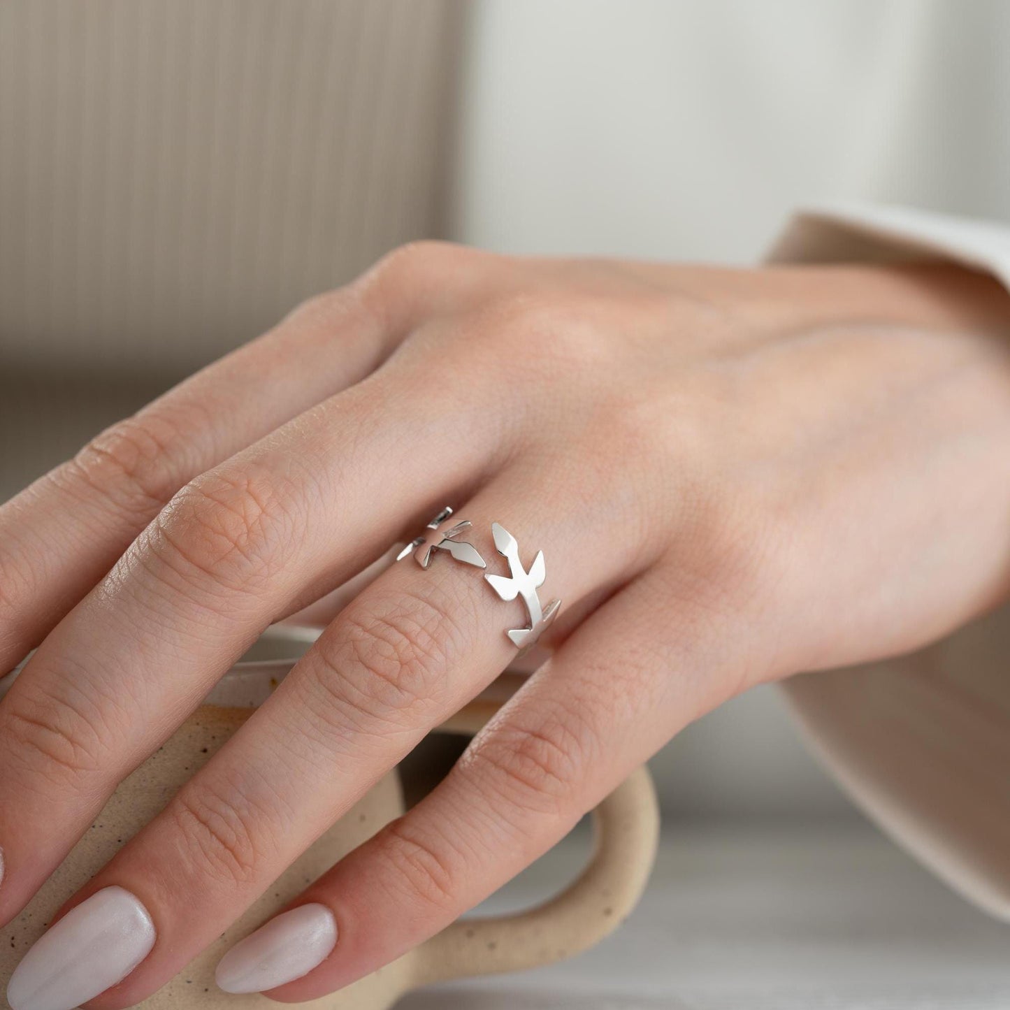 A delicate olive branch-inspired ring crafted from 925 Sterling Silver, available in gold and rose gold plating. Adjustable open band, perfect for nature lovers and elegant gifting.