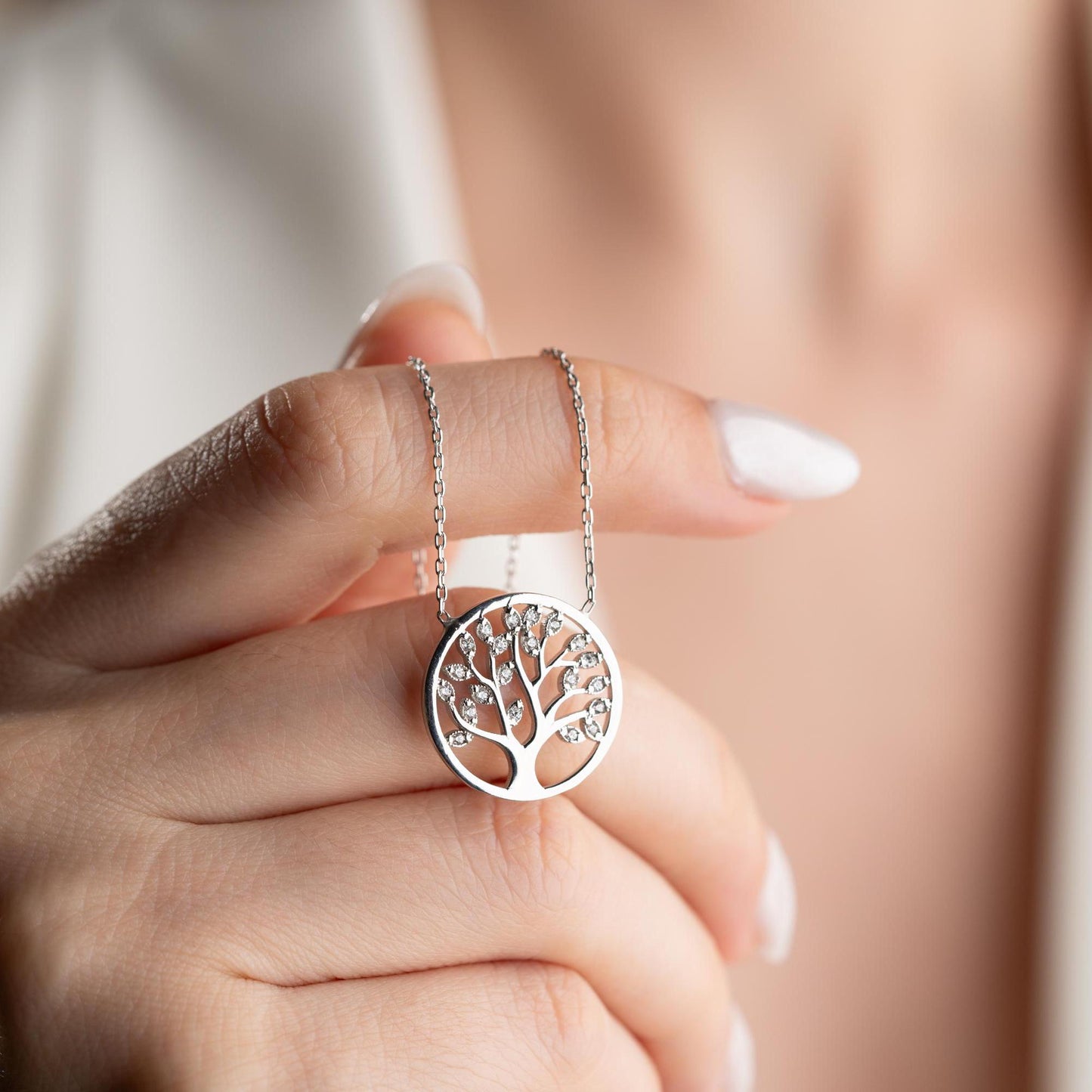 Tree of Life pendant necklace with cubic zirconia stones, available in 925 sterling silver and 14K gold plated options, displayed on a white satin background