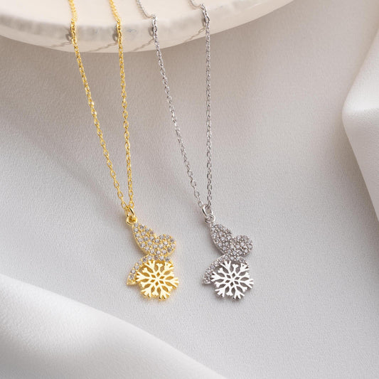 Snowflake heart necklace with cubic zirconia stones, available in 925 sterling silver and 14K gold plated options, displayed on a white satin background