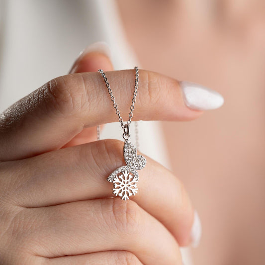 Snowflake heart necklace with cubic zirconia stones, available in 925 sterling silver and 14K gold plated options, displayed on a white satin background
