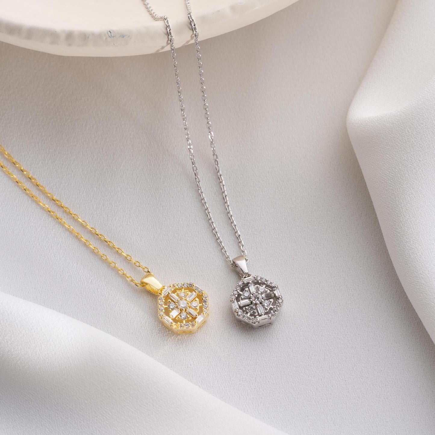 Octagon pendant necklace with cubic zirconia stones, available in 925 sterling silver and 14K gold plated options, displayed on a white satin background