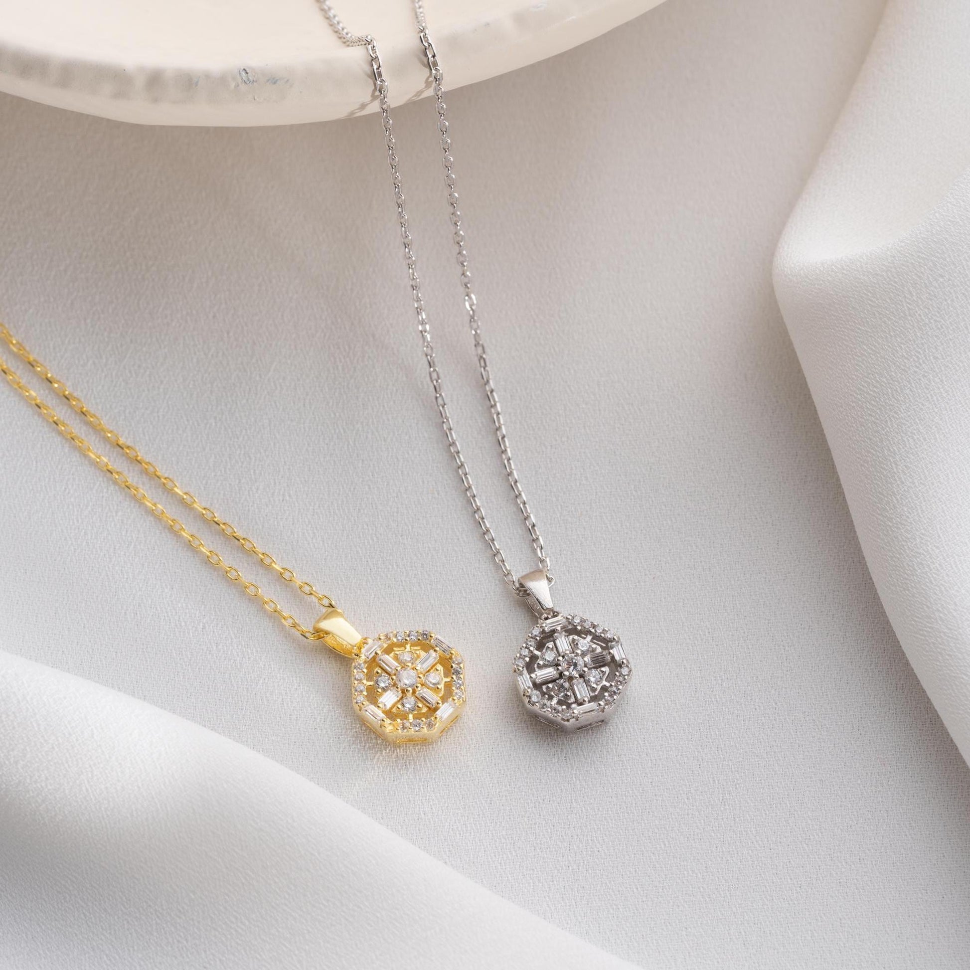 Octagon pendant necklace with cubic zirconia stones, available in 925 sterling silver and 14K gold plated options, displayed on a white satin background