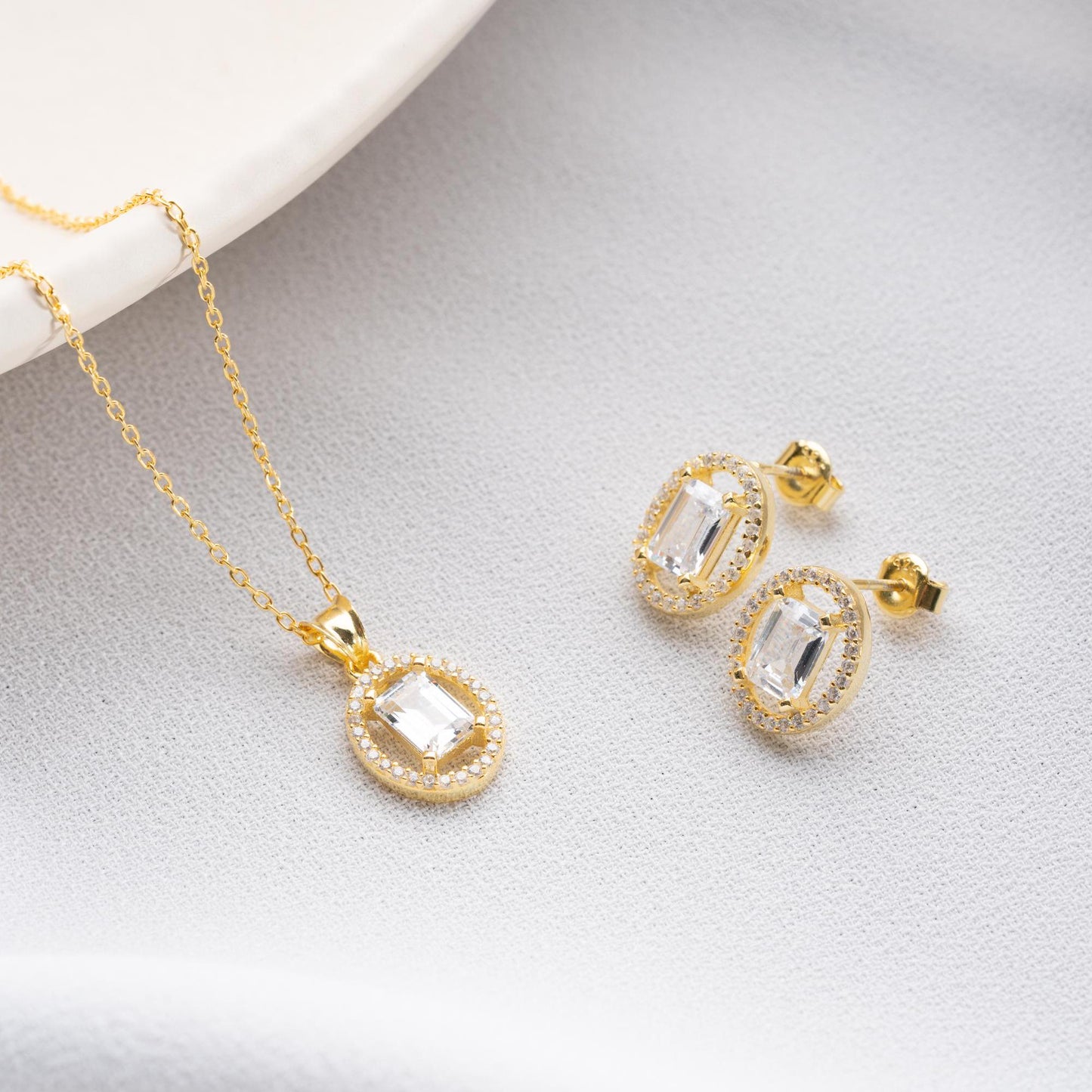 Oval elegance jewelry set with pendant necklace and earrings, featuring cubic zirconia stones, available in 925 sterling silver and 14K gold-plated options.