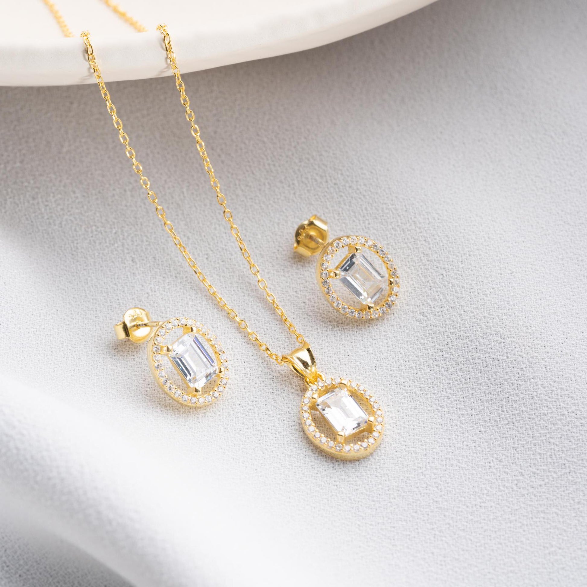 Oval elegance jewelry set with pendant necklace and earrings, featuring cubic zirconia stones, available in 925 sterling silver and 14K gold-plated options.