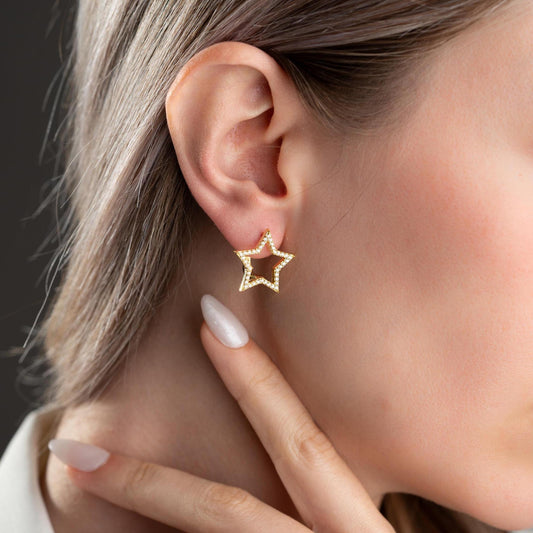 Star-shaped earrings with cubic zirconia stones, available in 925 sterling silver and 14K gold plated options, displayed on a minimalist background.