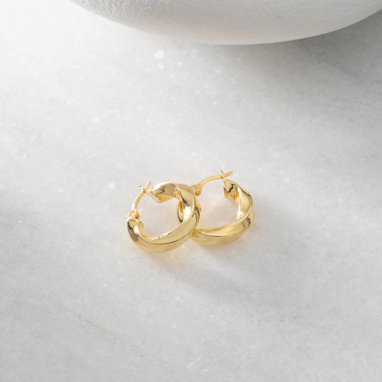 Twist hoop earrings in 925 Sterling Silver and 14K Gold Plated options, perfect for minimalist and elegant looks.
