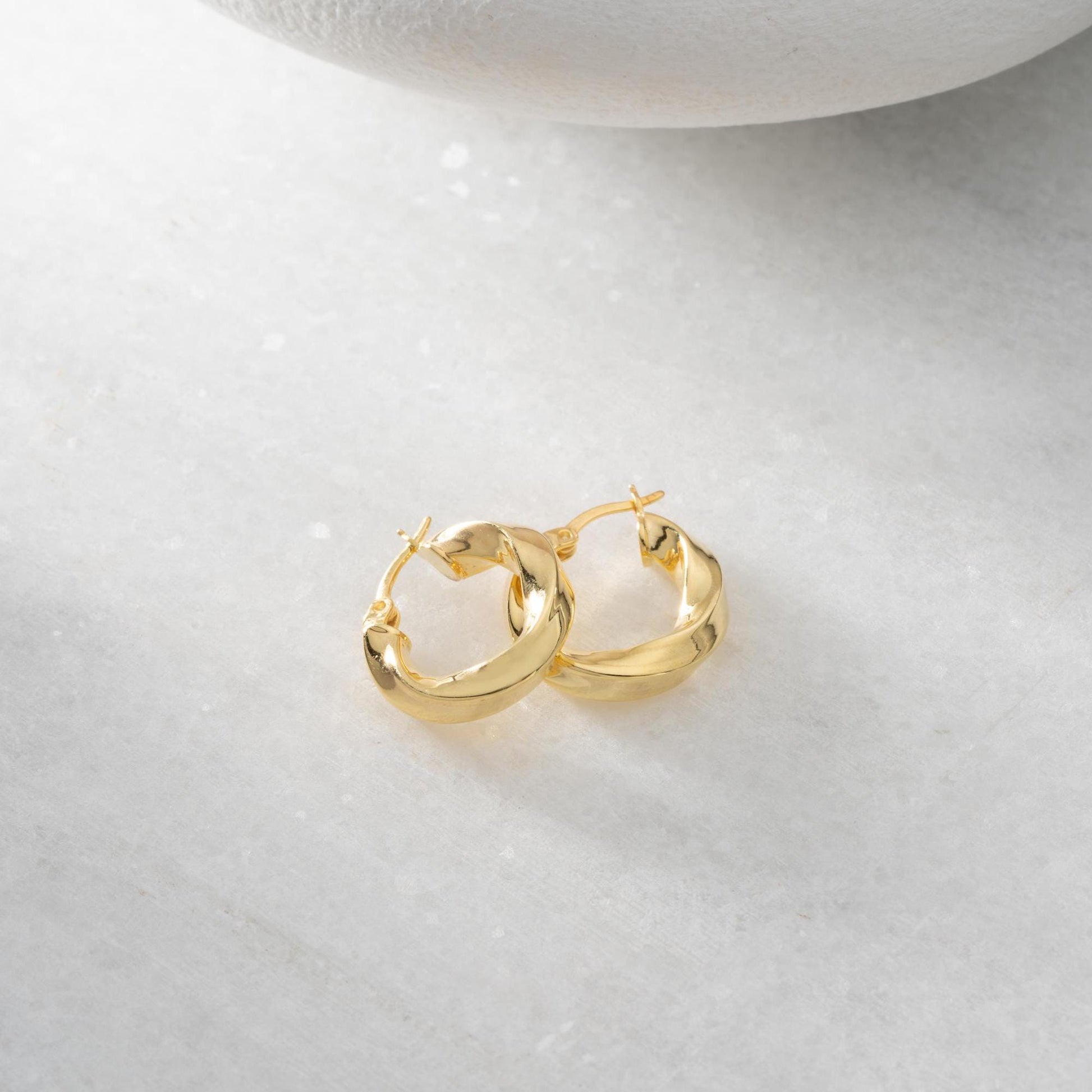 Twist hoop earrings in 925 Sterling Silver and 14K Gold Plated options, perfect for minimalist and elegant looks.