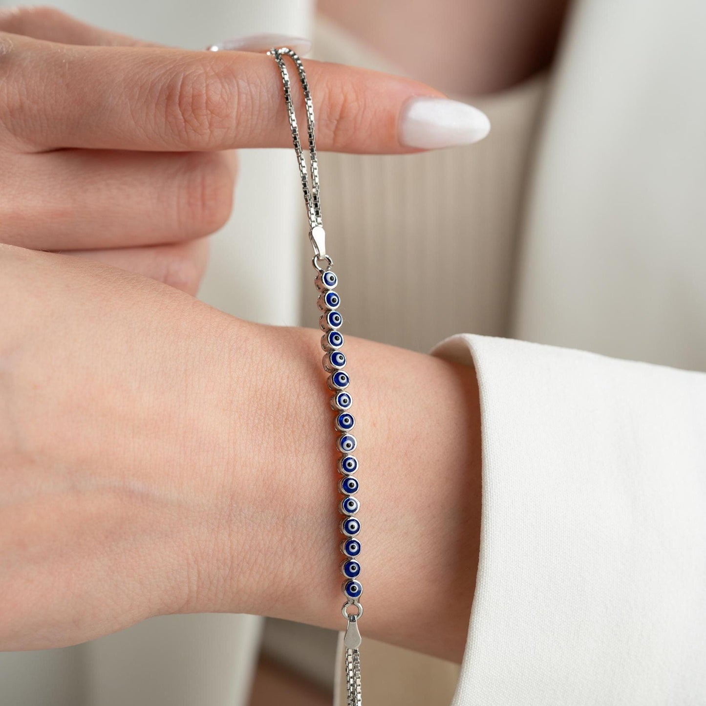 Evil eye bracelet crafted from 925 sterling silver with a 14K gold-plated option, featuring protective and stylish evil eye charms.