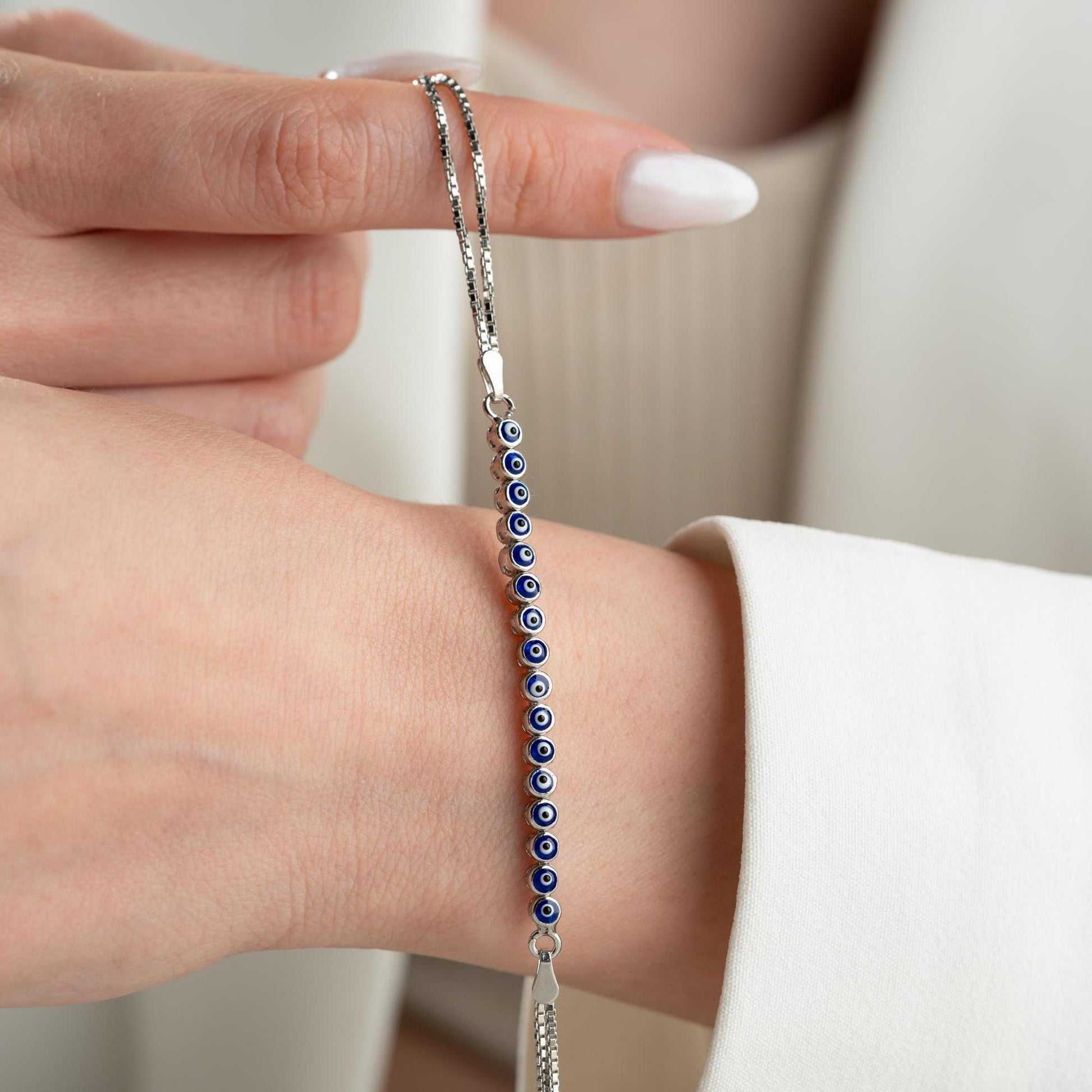 Evil eye bracelet crafted from 925 sterling silver with a 14K gold-plated option, featuring protective and stylish evil eye charms.