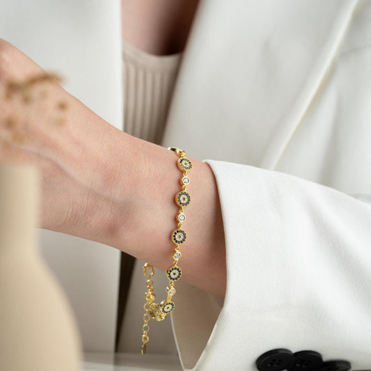 Evil Eye Charm Bracelet crafted in 925 Sterling Silver with cubic zirconia stones and intricate evil eye motifs, available in gold and silver finishes.