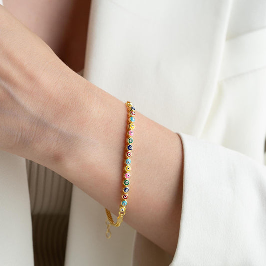 Vibrant charm bracelet featuring multicolored evil eye designs, crafted in 925 Sterling Silver, available in silver and gold finishes, perfect for gifting.
