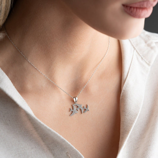 Elegant three seagulls silver necklace with sparkling zircon gemstones detail on a light background.