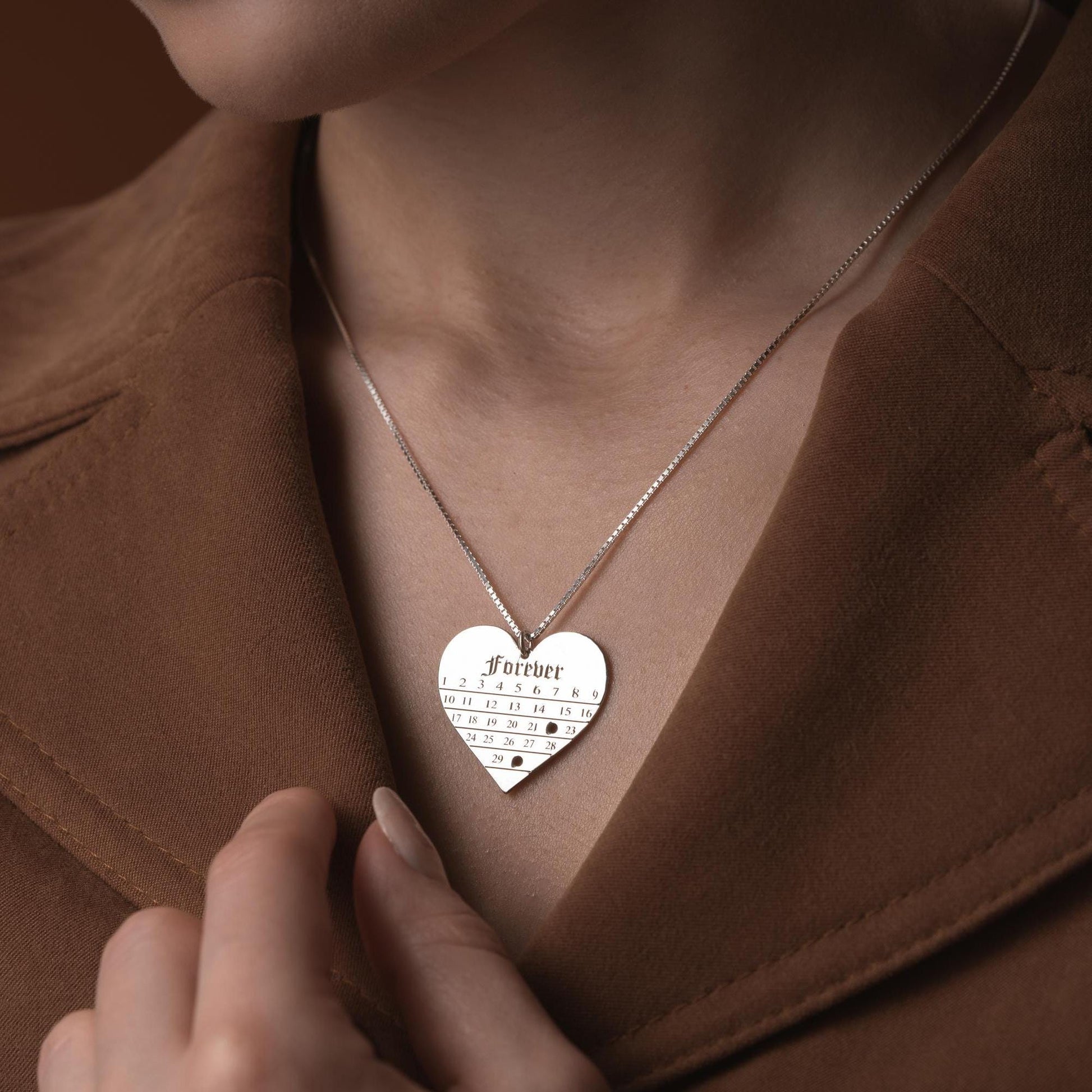 A personalized heart-shaped calendar necklace with a custom date engraving, available in sterling silver and gold plated finishes. Perfect for anniversaries, weddings, or Valentine&#39;s Day.