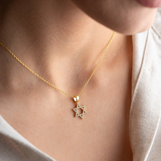 Close-up of a sparkling zircon-embellished Star of David pendant made of 925 sterling silver against a soft white background.